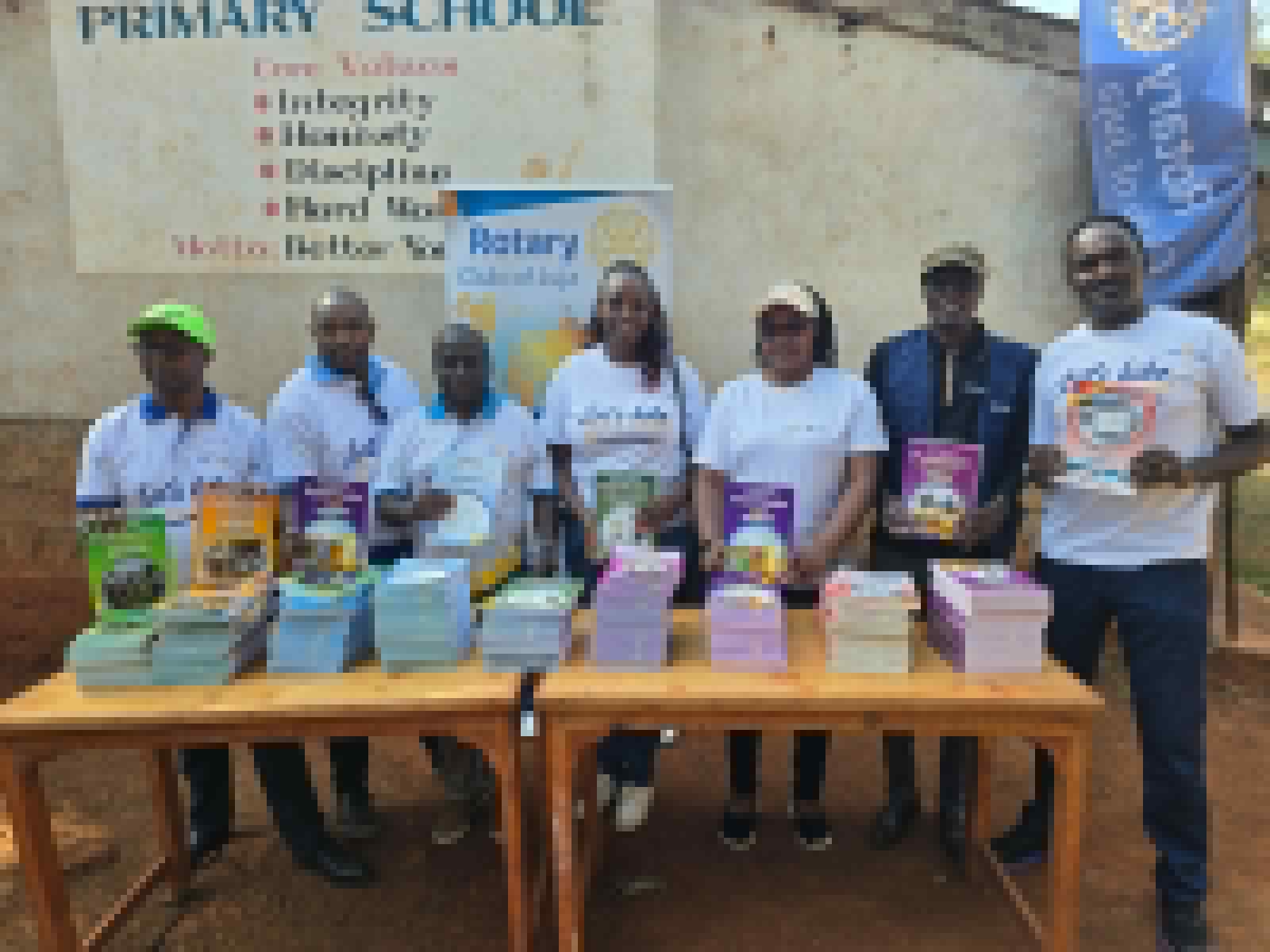 Rotary Club of Juja members displaying the donated curriculum books at Karakuta Primary School